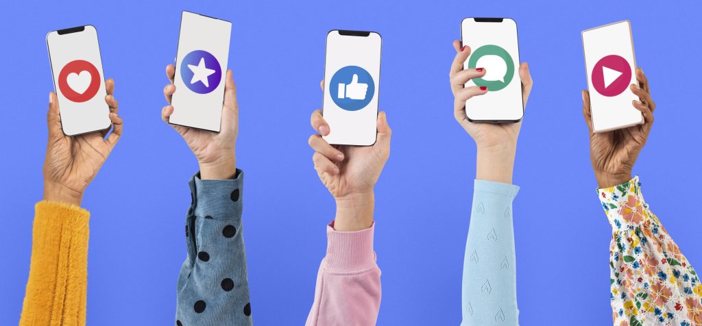Hands holding up phones showing social media icons