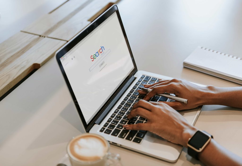 Hands typing on a laptop with a website open